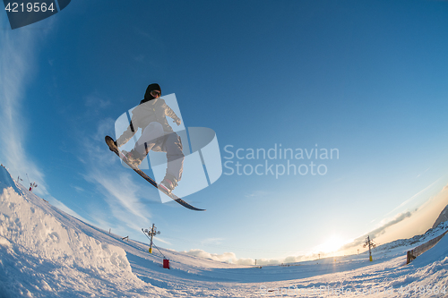 Image of Snowboarder jumping against blue sky