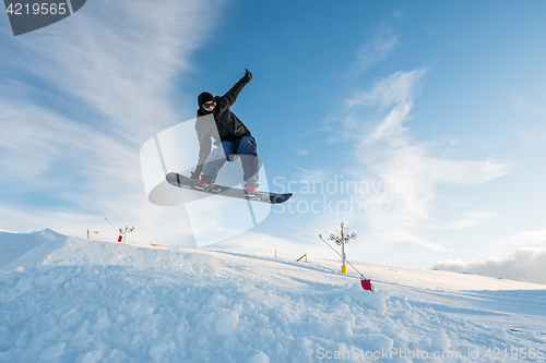 Image of Snowboarder jumping against blue sky