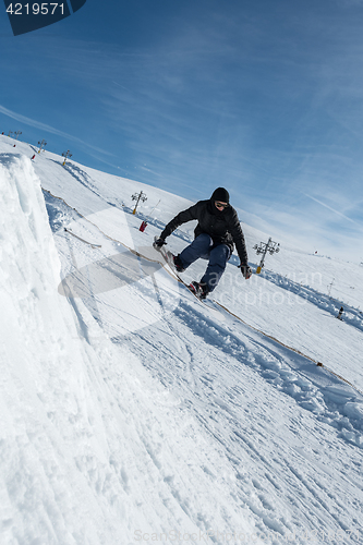 Image of Snowboarder jumping against blue sky