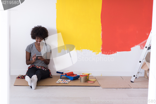 Image of back female painter sitting on floor