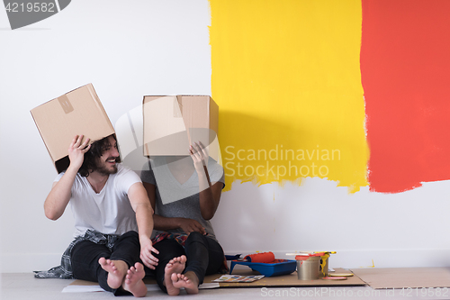 Image of young multiethnic couple playing with cardboard boxes