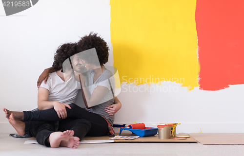 Image of young multiethnic couple relaxing after painting