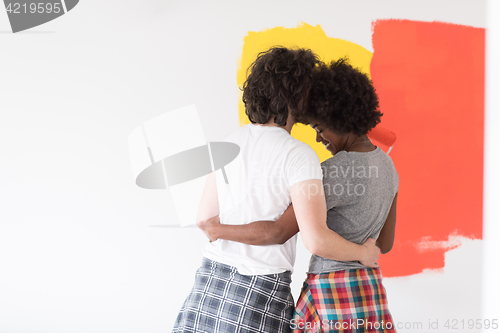 Image of multiethnic couple painting interior wall