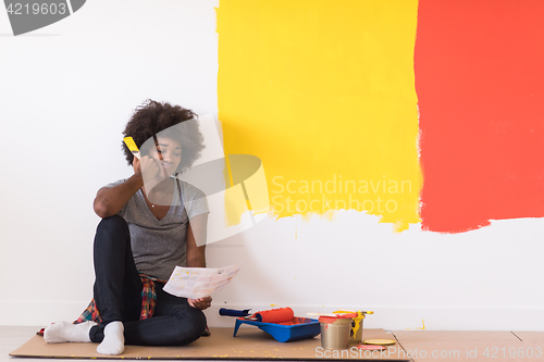 Image of back female painter sitting on floor