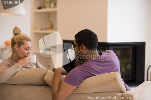 Image of Young multiethnic couple  in front of fireplace
