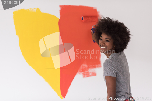 Image of black woman painting wall