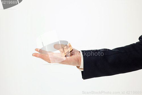 Image of Man\'s hands holding wooden puzzle.