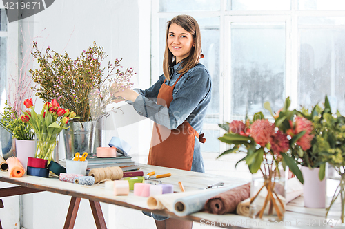 Image of Florist at work: the young girl making fashion modern bouquet of different flowers