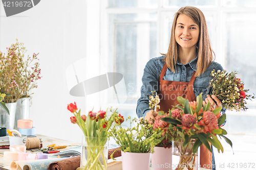 Image of Florist at work: the young girl making fashion modern bouquet of different flowers