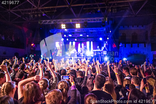 Image of The silhouettes of concert crowd in front of bright stage lights