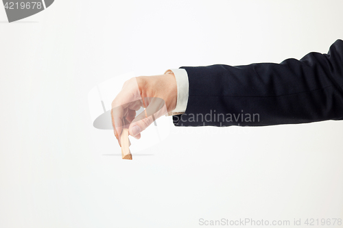 Image of Man\'s hands holding wooden puzzle.