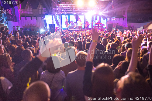 Image of The silhouettes of concert crowd in front of bright stage lights