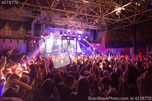 Image of The silhouettes of concert crowd in front of bright stage lights