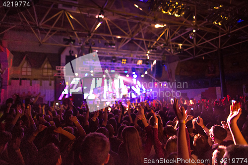 Image of The silhouettes of concert crowd in front of bright stage lights