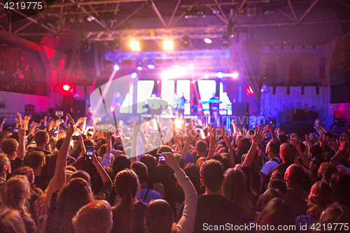 Image of The silhouettes of concert crowd in front of bright stage lights