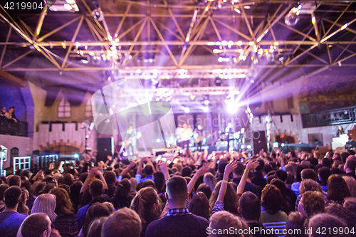 Image of The silhouettes of concert crowd in front of bright stage lights