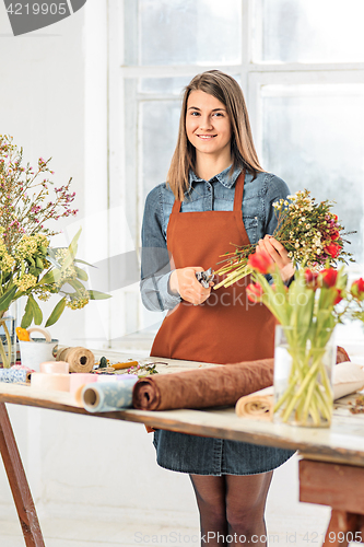 Image of Florist at work: the young girl making fashion modern bouquet of different flowers