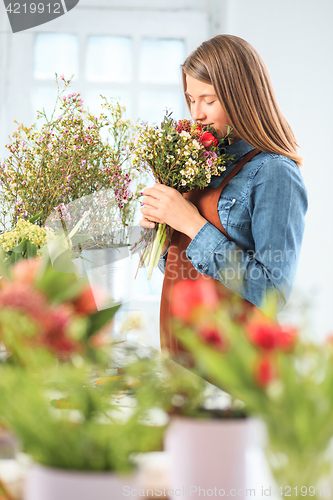 Image of Florist at work: the young girl making fashion modern bouquet of different flowers