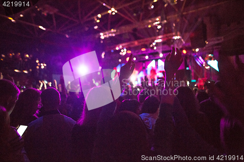 Image of The silhouettes of concert crowd in front of bright stage lights