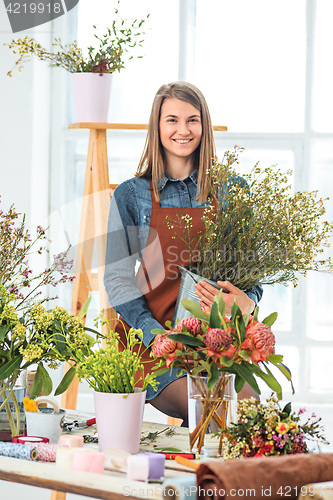 Image of Florist at work: the young girl making fashion modern bouquet of different flowers