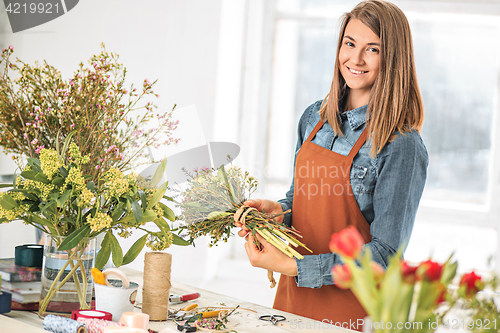 Image of Florist at work: the young girl making fashion modern bouquet of different flowers