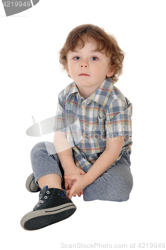 Image of Little three year boy sitting on floor.