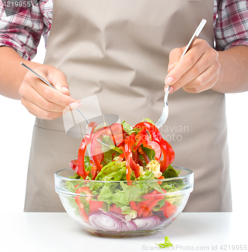 Image of Cook is mixing salad