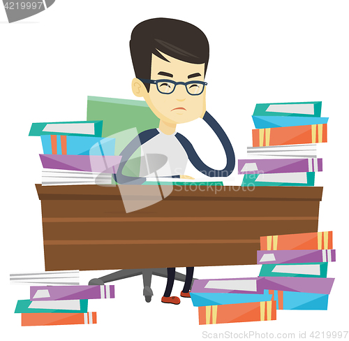 Image of Student sitting at the table with piles of books.