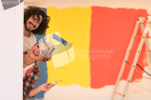 Image of portrait of a couple painting interior wall