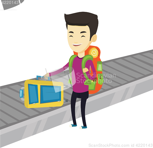 Image of Man picking up suitcase on luggage conveyor belt