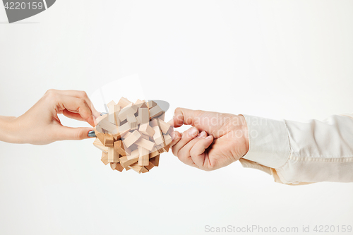 Image of The toy wooden puzzle in hands isolated on white background
