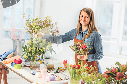 Image of Florist at work: the young girl making fashion modern bouquet of different flowers