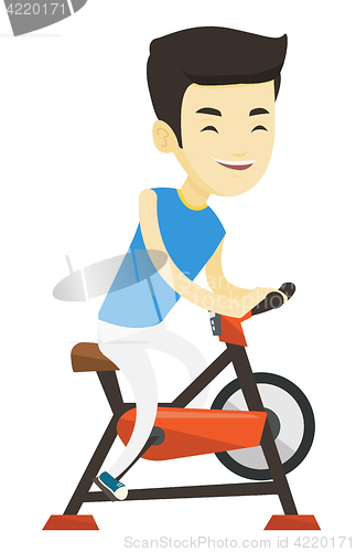 Image of Young man riding stationary bicycle.