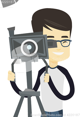 Image of Cameraman with movie camera on tripod.