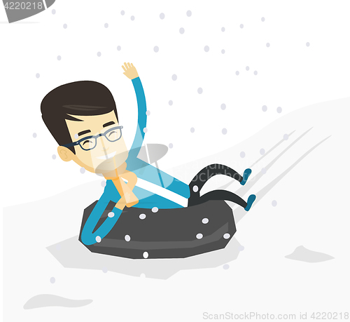 Image of Man sledding on snow rubber tube in the mountains.