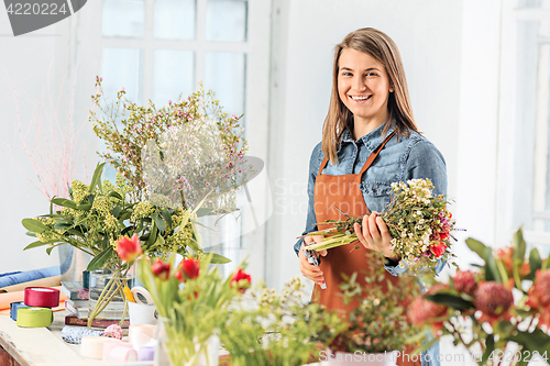 Image of Florist at work: the young girl making fashion modern bouquet of different flowers