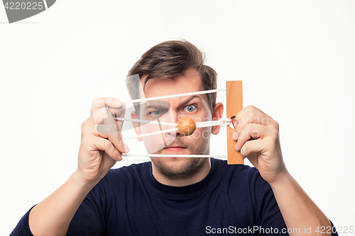 Image of Attractive 25 year old business man looking confused at wooden puzzle.