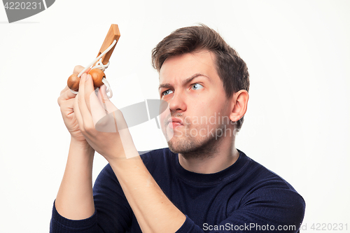 Image of Attractive 25 year old business man looking confused at wooden puzzle.