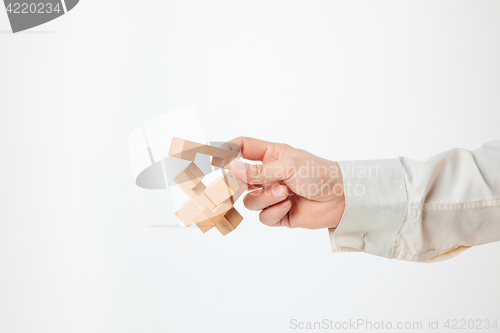 Image of The toy wooden puzzle in hand isolated on white background