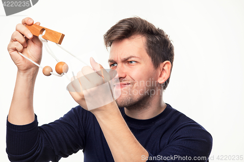 Image of Attractive 25 year old business man looking confused at wooden puzzle.