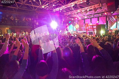 Image of The silhouettes of concert crowd in front of bright stage lights