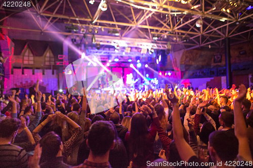 Image of The silhouettes of concert crowd in front of bright stage lights