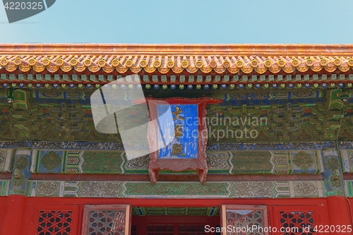 Image of Name plate on decorated Chinese roof displaying harmony