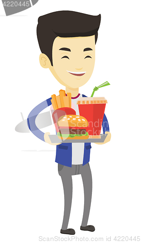 Image of Man holding tray full of fast food.