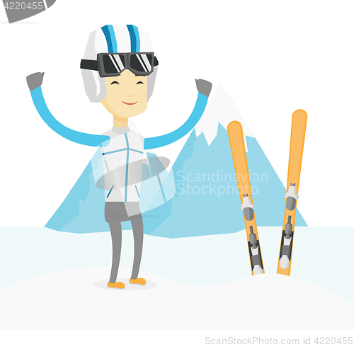 Image of Cheerful skier standing with raised hands.