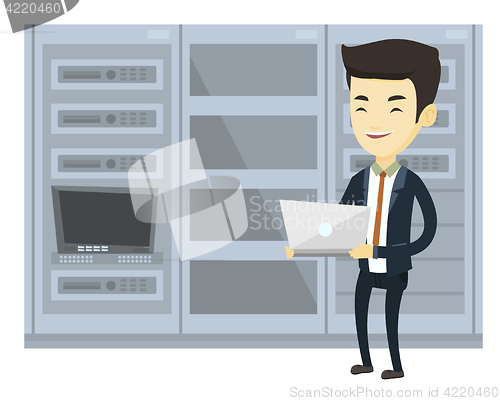 Image of Engineer working on laptop in network server room.