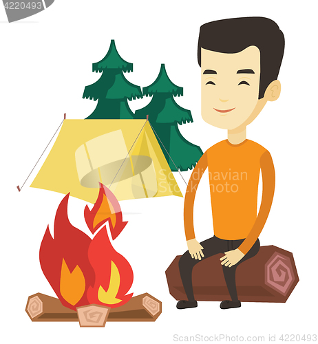 Image of Man sitting on log near campfire in the camping.