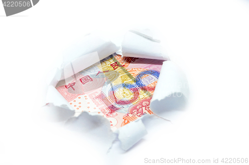 Image of China currency through torn white paper