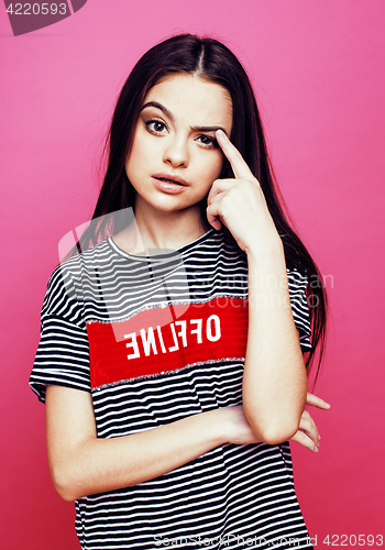 Image of young pretty teenage woman emotional posing on pink background, fashion lifestyle people concept 