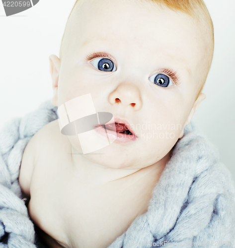 Image of little cute red head baby in scarf all over him close up isolated, adorable kid winter clothers smiling, lifestyle real people concept